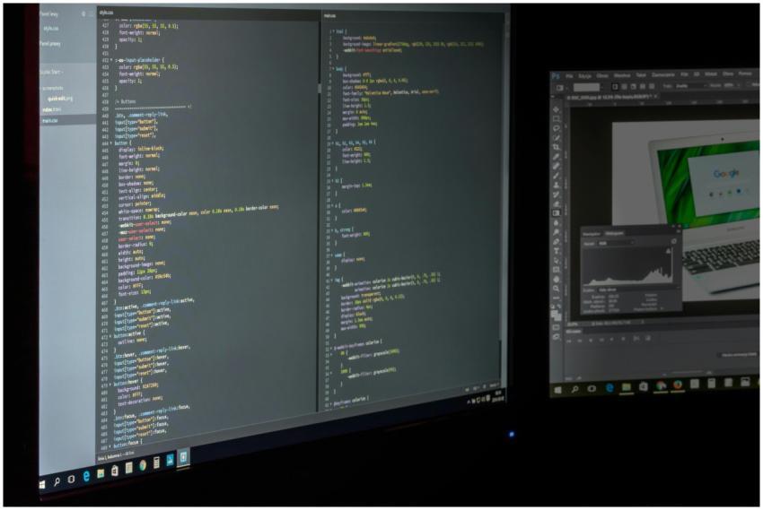 A dual screen setup showcasing programming code an