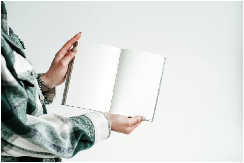 Close-up of a person holding a blank open notebook