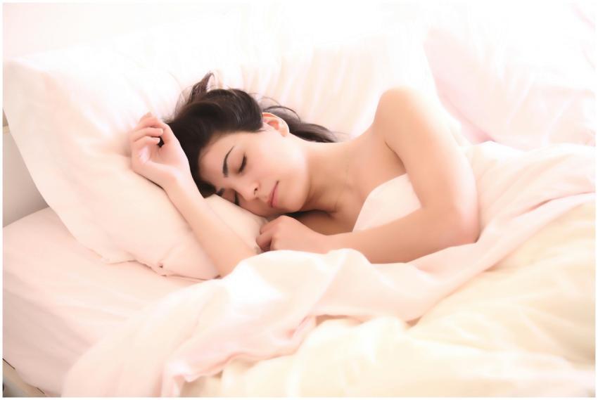 A serene woman sleeping comfortably on a bed with