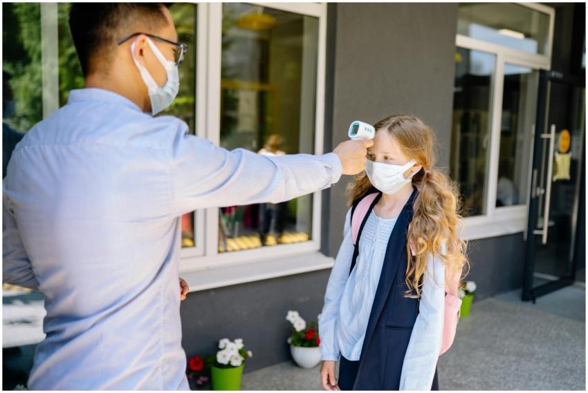 A schoolgirl undergoes a temperature screening as