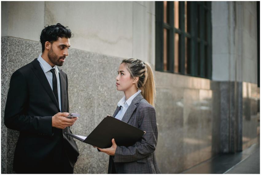 Two professionals in business attire discussing wo