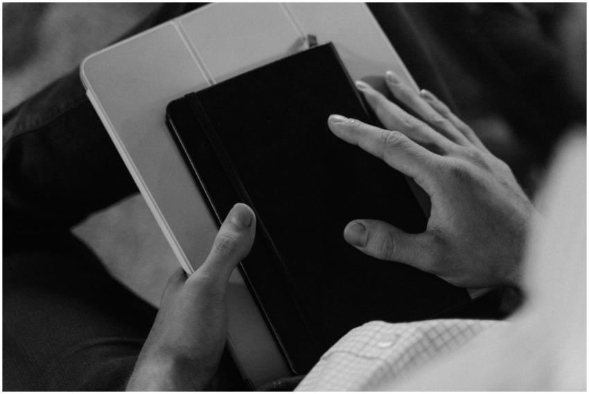 Black and white image of hands holding a book and