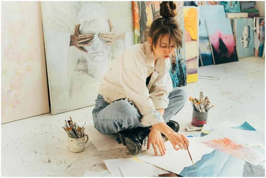 A creative young artist painting in a bright studi