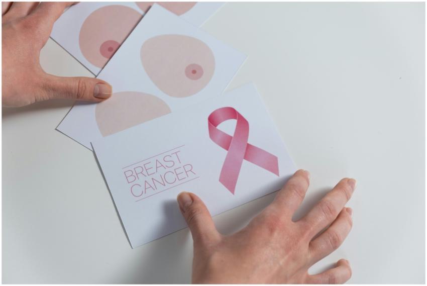 Hands arranging breast cancer awareness cards with