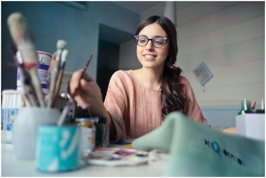 A young woman artist working with paintbrushes in