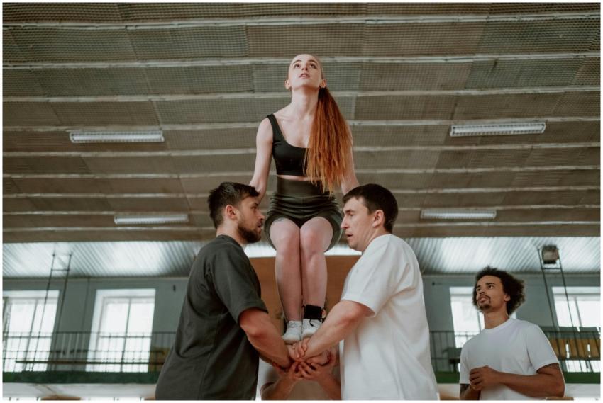 Group of individuals practicing a cheerleading stu