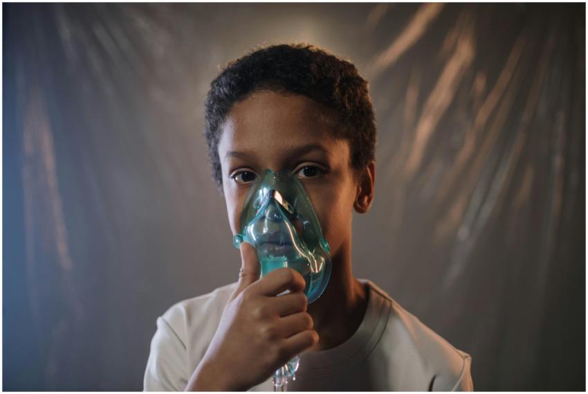Portrait of a child using an oxygen mask indoors,