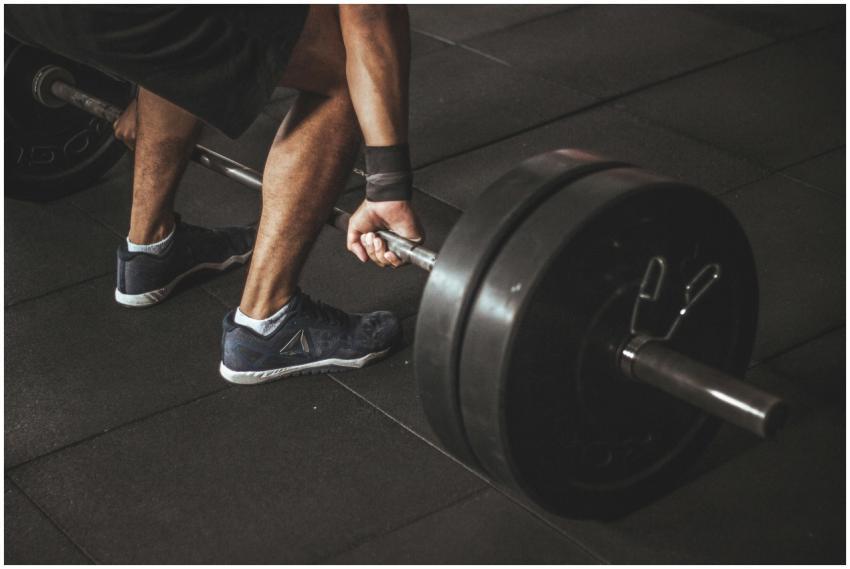 A man lifting a heavy barbell during a gym workout