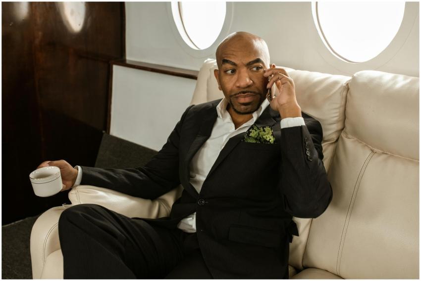 Businessman in a black suit seated in a private je
