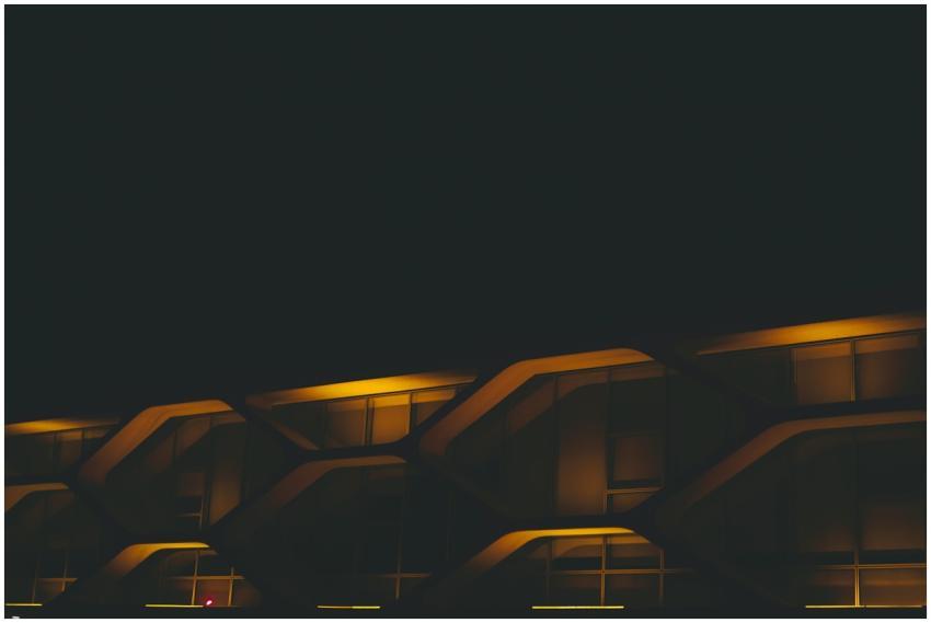 A modern building facade illuminated by neon light