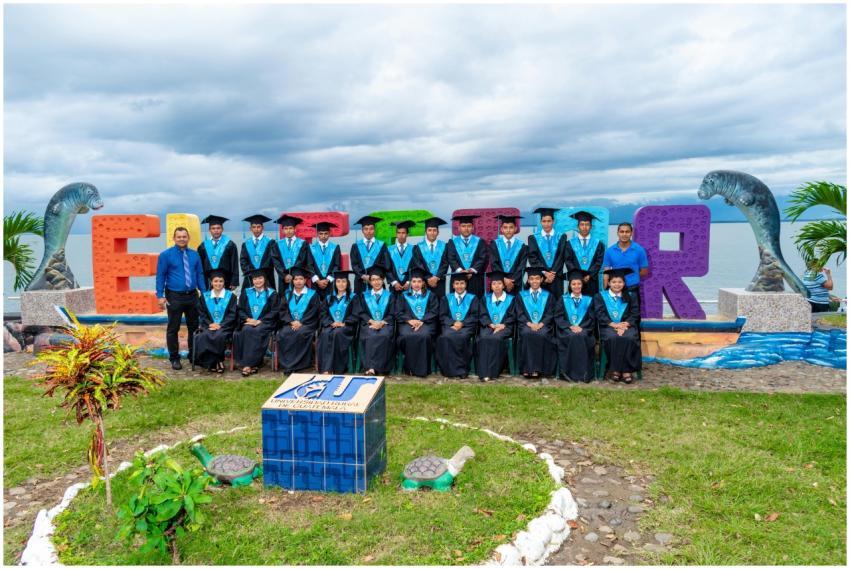 Group of adult graduates in gowns and caps celebra