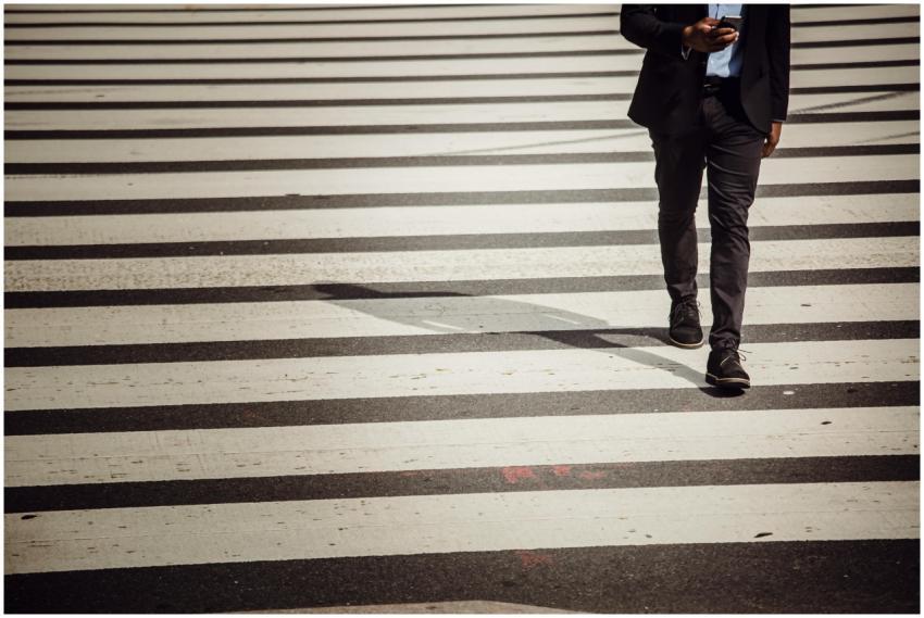A businessman using a smartphone walks across a ci