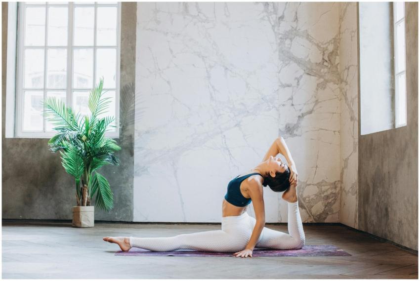 Woman doing yoga in Hanumanasana pose indoors, foc