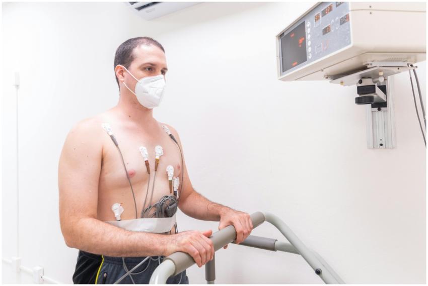 Man in medical exam wearing electrodes and face ma