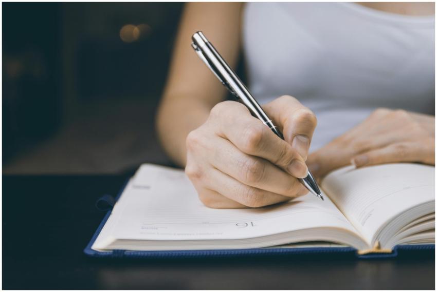 Woman writing in a notebook, capturing a moment of