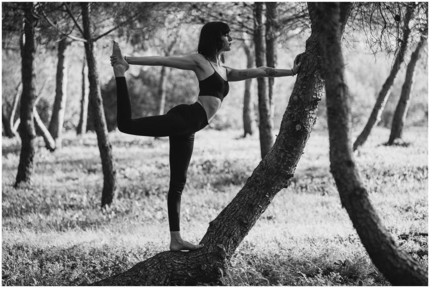 A woman performs the Natarajasana yoga pose surrou