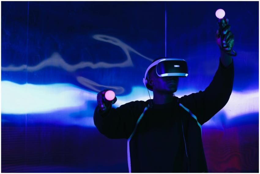 An adult male uses a VR headset and controllers in