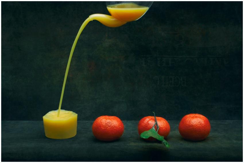 Artistic shot of fresh orange juice pouring from a