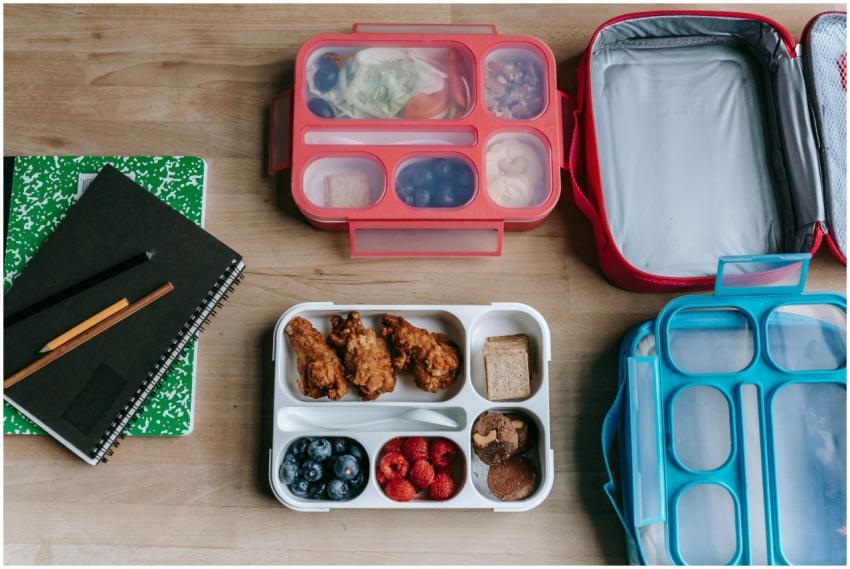 Overhead view of healthy lunchboxes with fruits, c