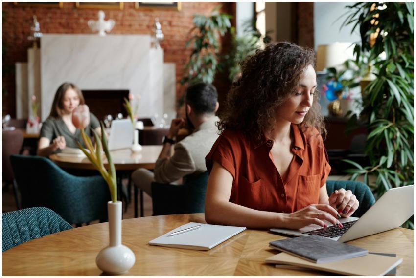 Woman with curly hair in a red shirt working on a