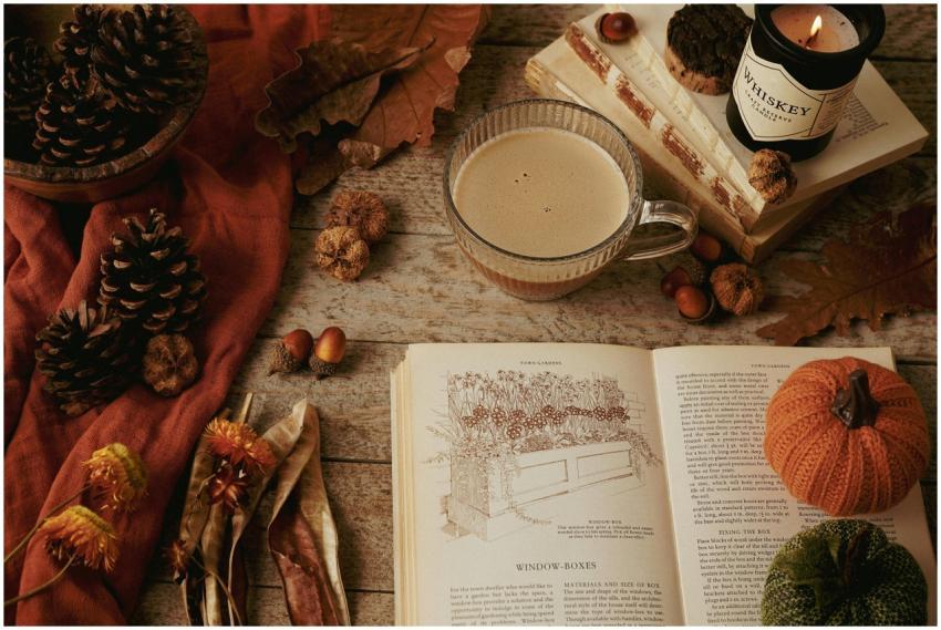 Warm autumn still life with coffee, candles, books