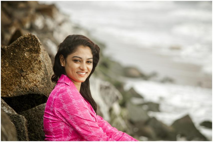 Woman in a vibrant pink outfit smiles sitting on r