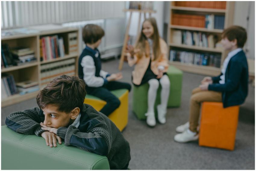 A sad child isolated in a school library while pee
