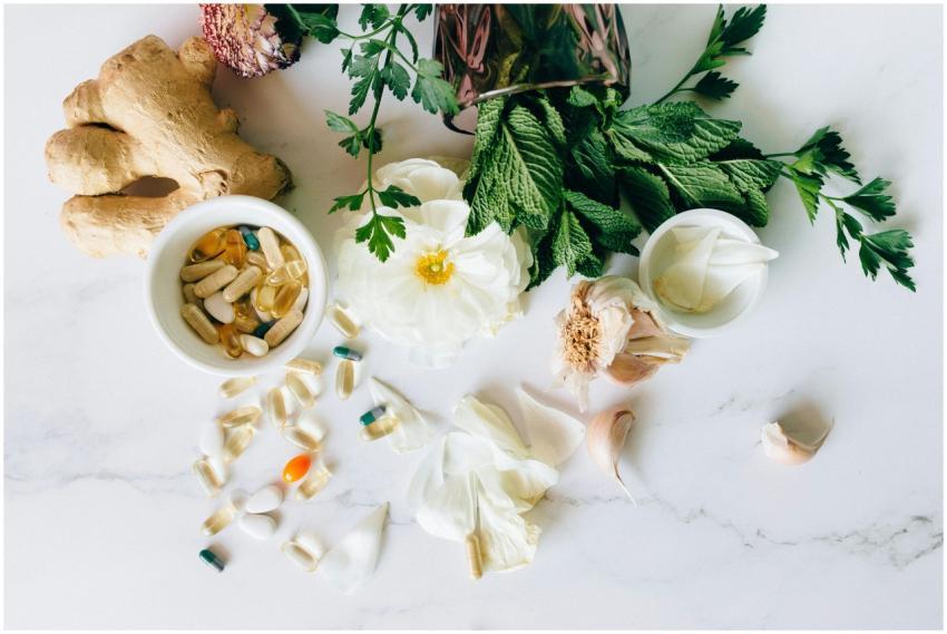 A flatlay of herbal supplements with fresh ginger,