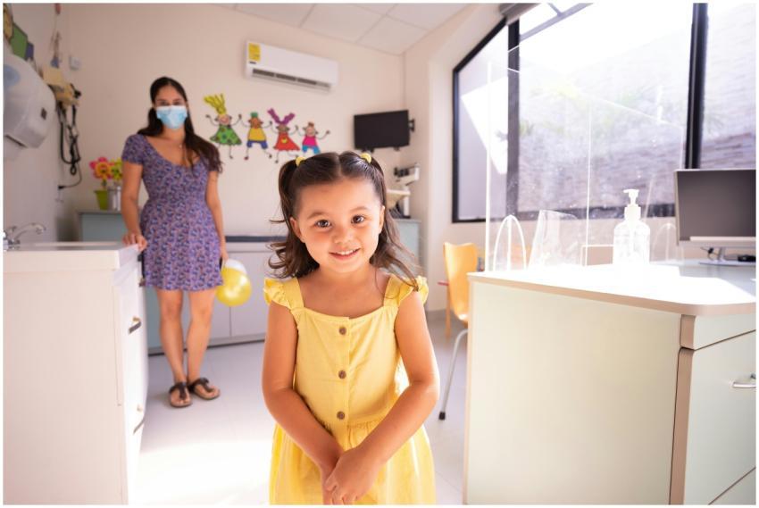 A cheerful child in a yellow dress at a pediatric