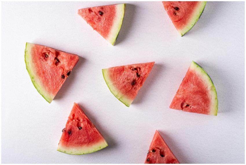 A flat lay image of juicy watermelon slices on a w