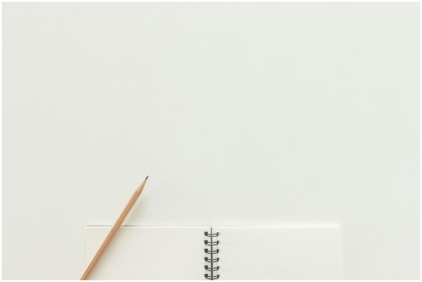 A top view of a spiral notebook with pencil on a n