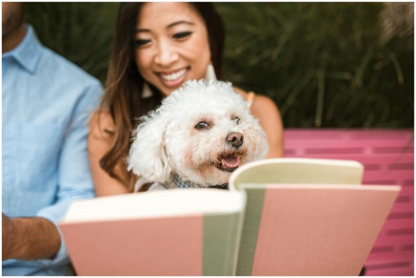 A woman and her fluffy dog enjoying a book togethe