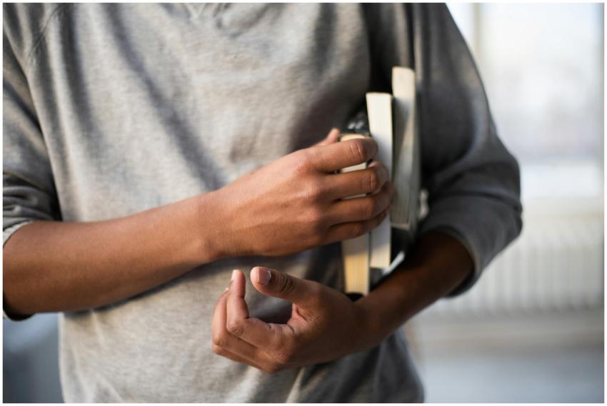Crop anonymous ethnic male in casual clothes stand