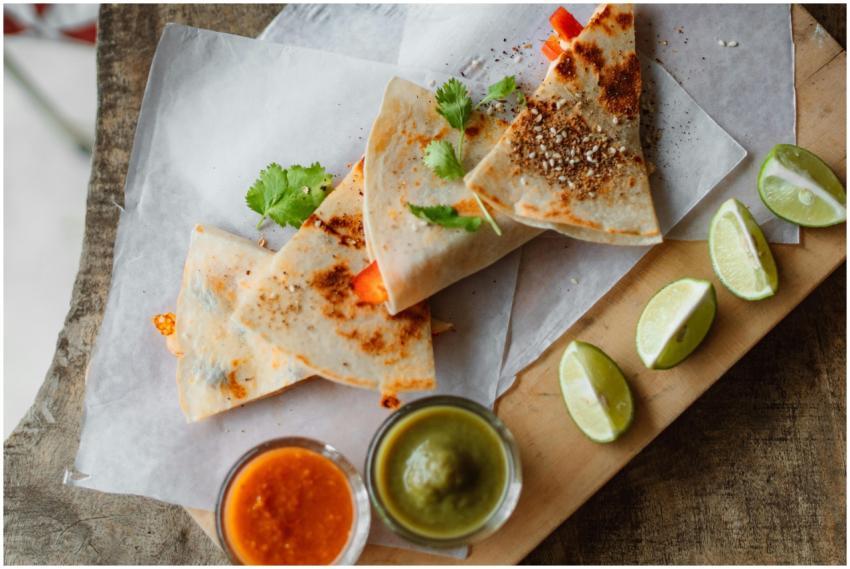 Top view of quesadillas served with salsa and lime