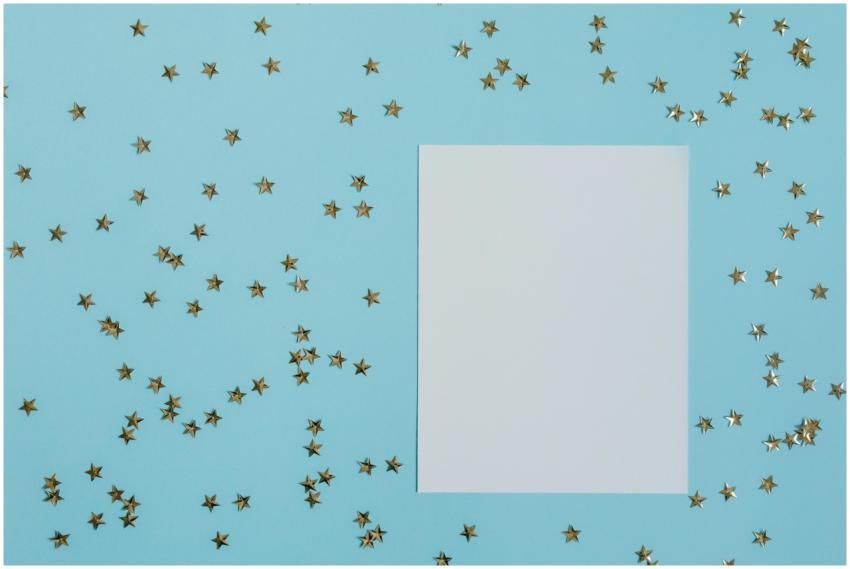A blank sheet surrounded by gold star confetti on