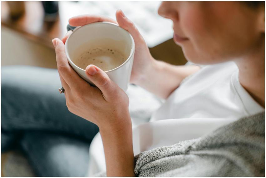 A woman enjoys a warm cup of coffee indoors, captu