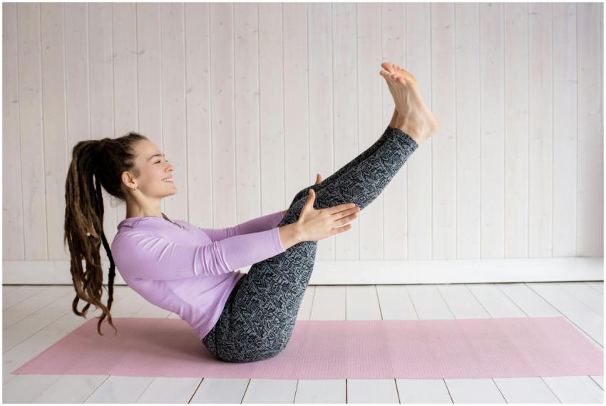 Young woman performing a yoga pose on a pink mat i
