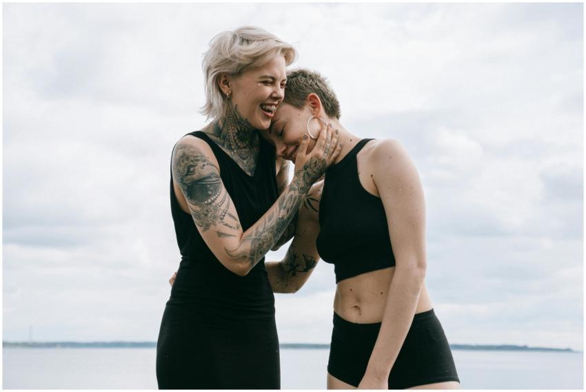 A happy lesbian couple in black attire laughing to