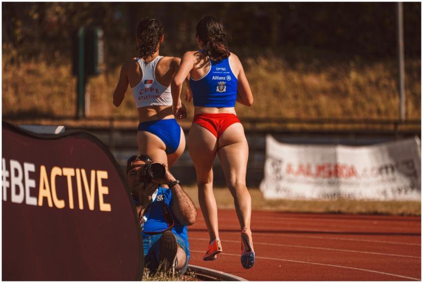 Two female athletes running on a track during a sp