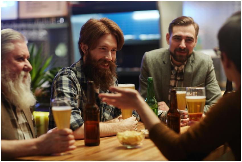 Four friends with beards enjoying drinks and conve