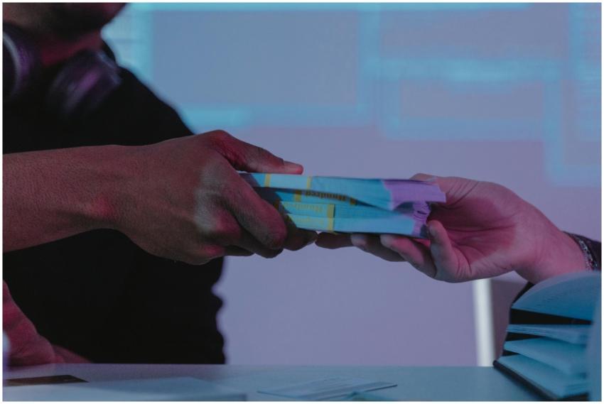 Close-up of hands exchanging money, highlighting f