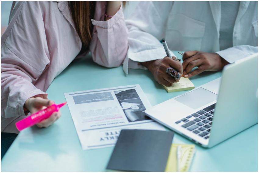 Two women collaborating on a project using a lapto