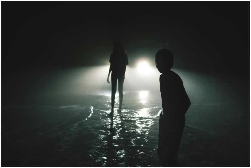 Eerie night scene with children's silhouetted figu