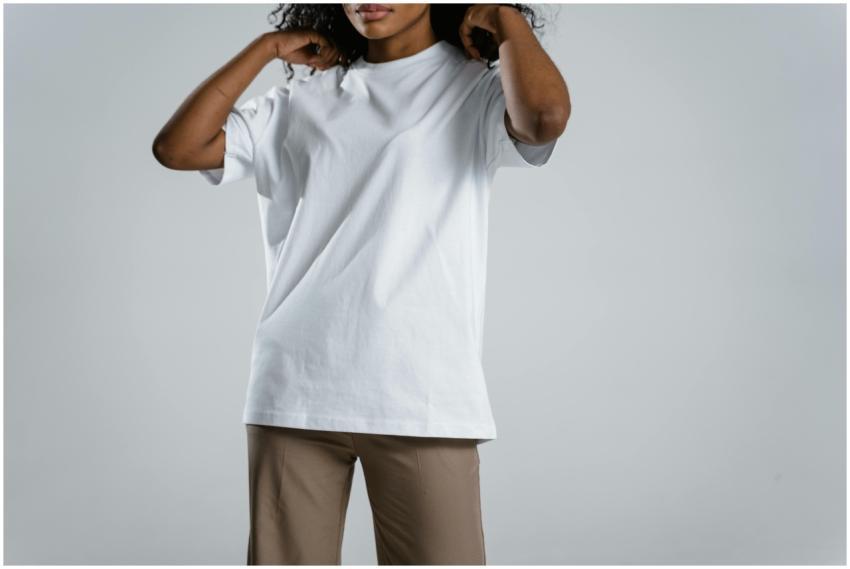 Woman wearing a white t-shirt and brown pants, adj