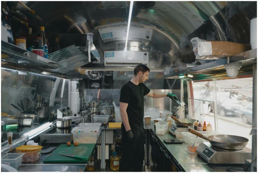 A man preparing food inside a stainless steel inte