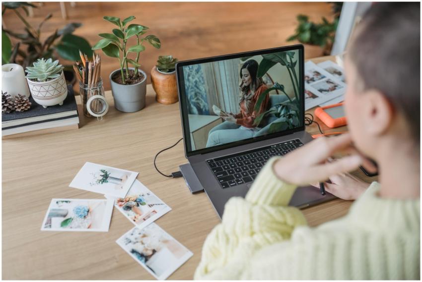 A woman working on a laptop at a desk with plants