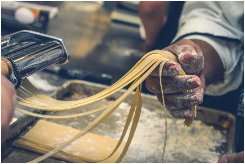 Close-up of hands making fresh pasta, showcasing a