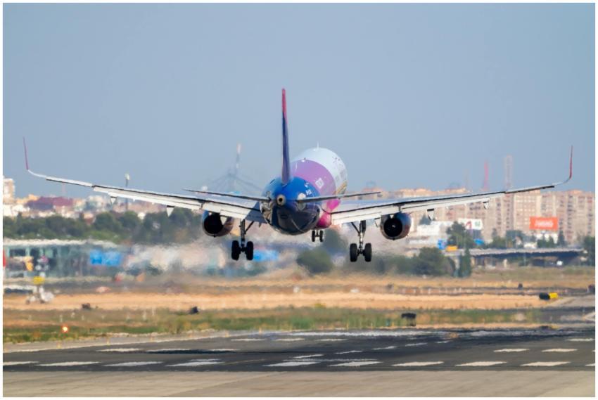 A vibrant airplane lands on the runway at Manises