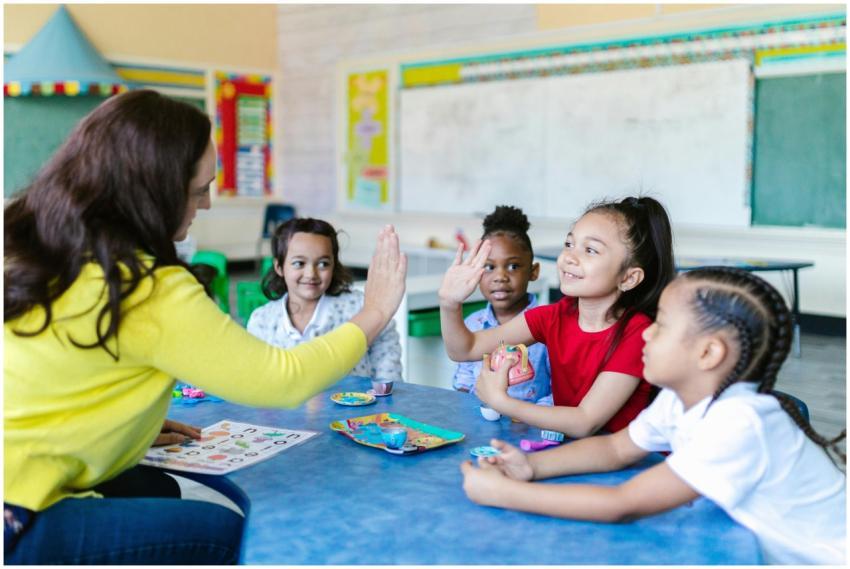 Teacher and diverse students high-five in a lively