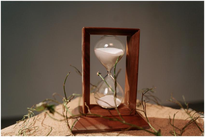 Close-up of a wooden hourglass with sand flowing,